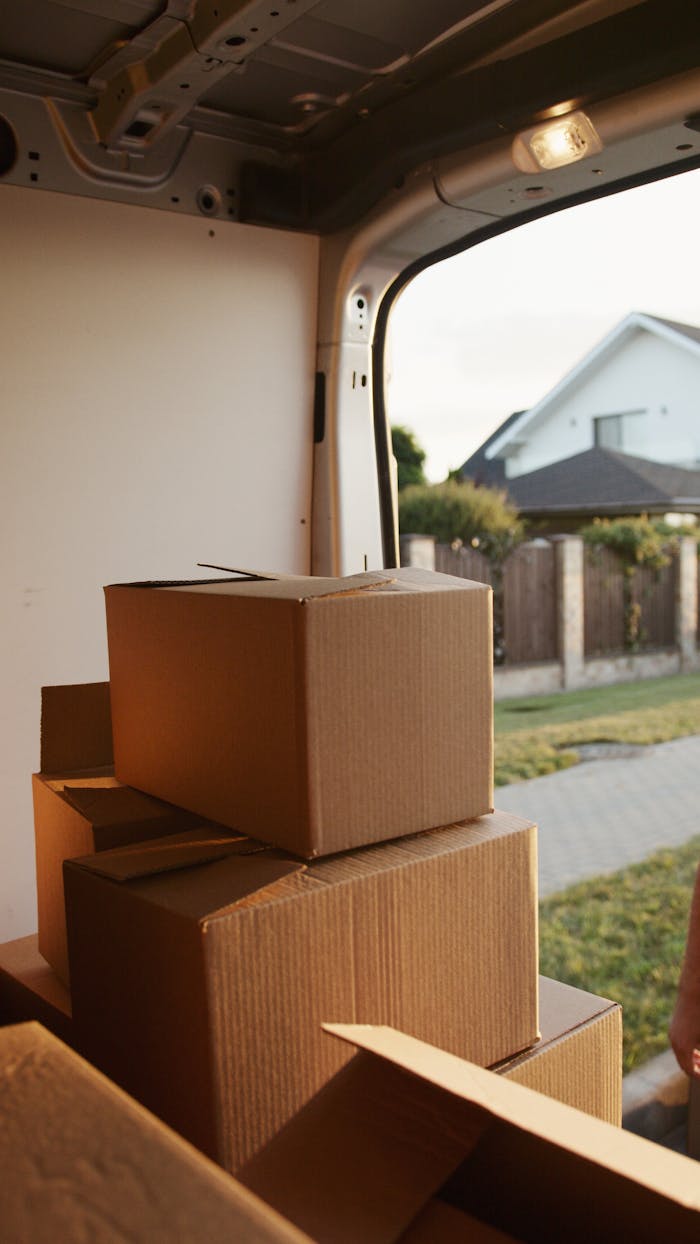 Services View inside a delivery van with stacked cardboard boxes ready for moving.